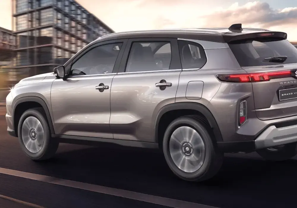 Suzuki Vitara, vista trasera de un SUV compacto de color plateado, en movimiento por una carretera urbana.