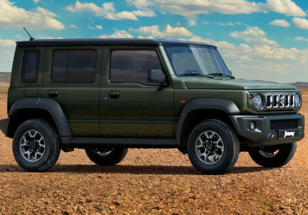 Suzuki Jimny verde oliva, un vehículo todoterreno compacto, está estacionado en un camino de tierra en un desierto.