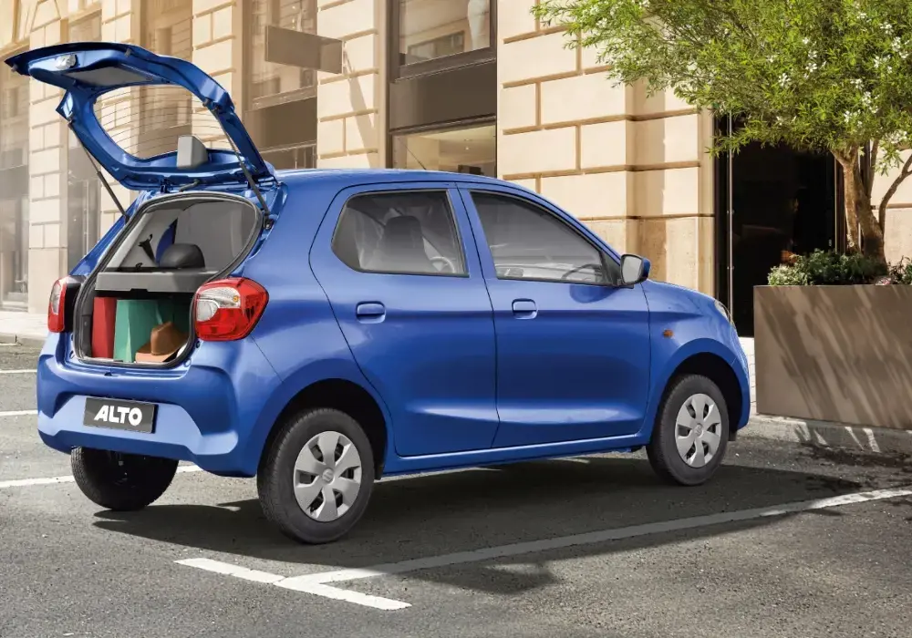 Suzuki Alto azul estacionado en la calle, con el portón trasero abierto.