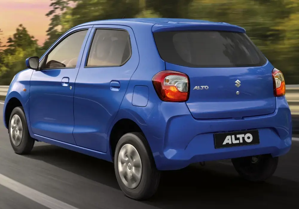 Suzuki Alto azul brillante se desplaza por una carretera