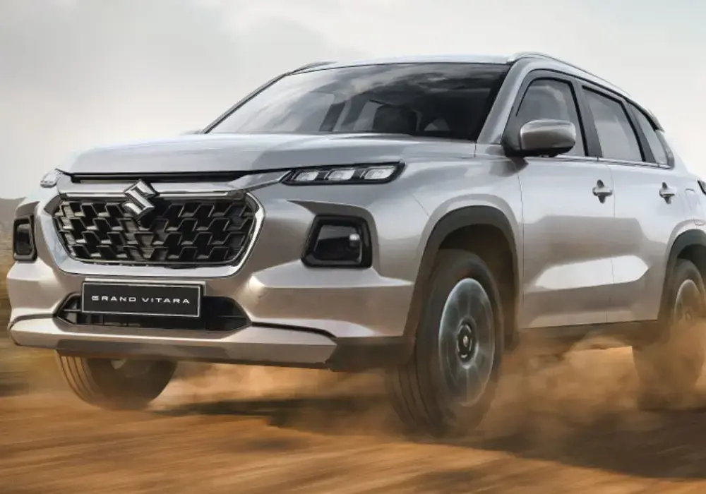 Suzuki Grand Vitara, un SUV 4x4 plateado desplazándose a alta velocidad por un camino de tierra.