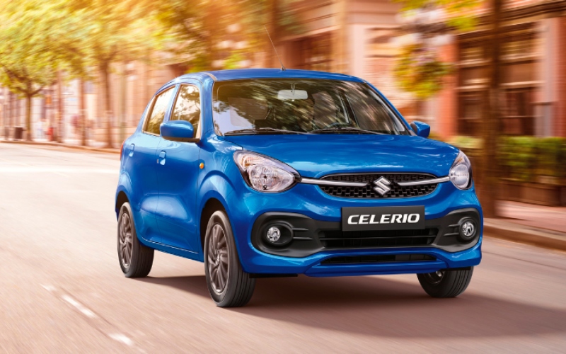 Suzuki Celerio azul en movimiento con árboles de fondo